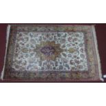 A pure silk Persian Qum rug, central floral medallion with stylised floral motifs on an ivory