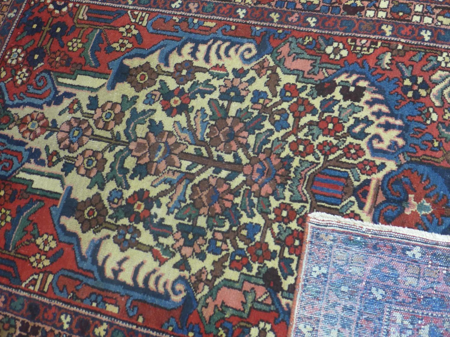 A Central Persian Bakhtiari rug, repeating stylised floral motifs on an ivory field, within stylised - Image 5 of 5