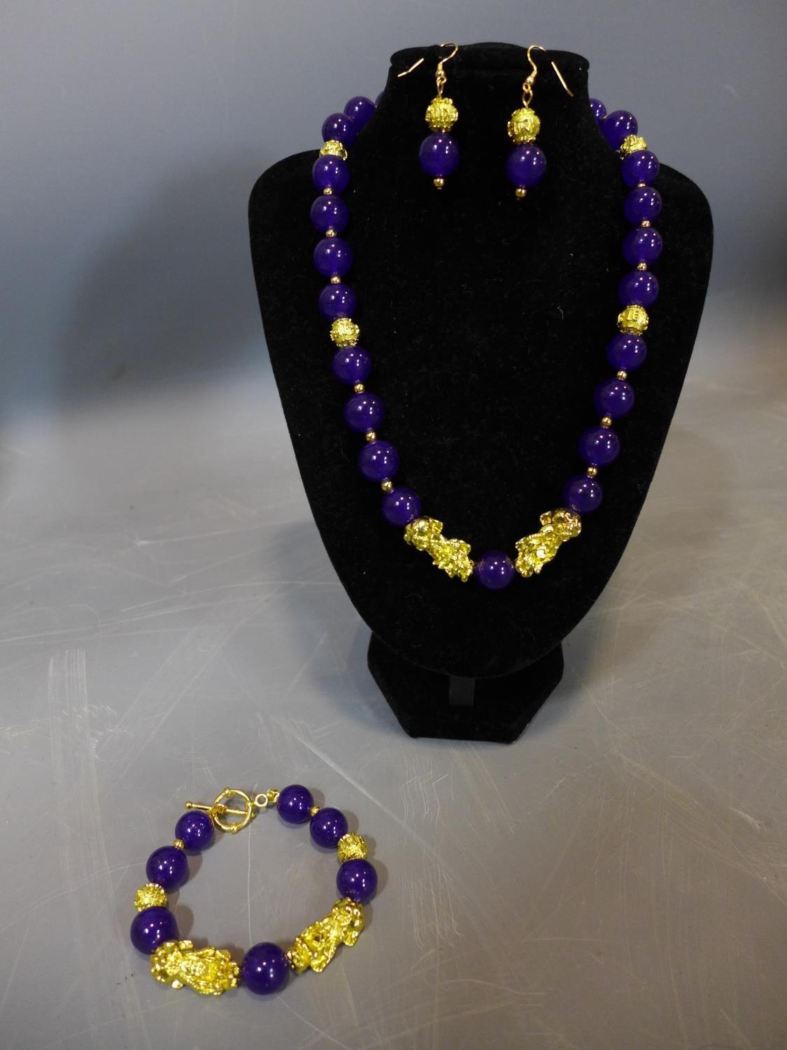 A beaded purple jade and gold plated jewellery suite, to include necklace, bracelet and earrings