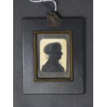 A 19th century silhouette portrait of a lady wearing a bonnet, in ebonised rectangular frame, 5.5