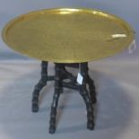 An Islamic brass top table, on carved hardwood base, H.55cm Diameter 67cm