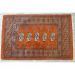 A small Persian Bokhara rug, with five elephant pad motifs on a red ground, 96 x 62cm