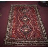 A South-West Persian Qashqai carpet, triple pole medallion with repeating petal motifs on a rouge