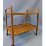 A mid 20th century Danish teak two tier trolley, raised on castors, stamped 'Made in Denmark', H.
