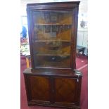 A large mahogany corner bookcase, with glazed door flanked by barley twist columns (one missing