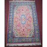 A Persian Tabriz rug, central floral medallion with stylised floral motifs on a pink ground,