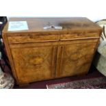 An Art Deco walnut sideboard, the quarter veneered top above two drawers and two cupboard doors,