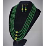 A Chinese four strand jadeite beaded necklace together with a pair of matching earrings