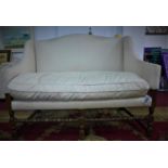 An early 20th century settee, with cream upholstery, on turned supports joined by stretchers, H.99