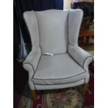 A pair of wingback armchairs, with linen and stud bound leather upholstery, on square legs