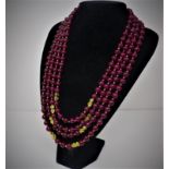 A Chinese four strand ruby beaded necklace with gold plated clasps