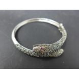A white metal and marcasite snake bangle with ruby eyes