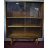 A mid 20th century glazed teak bookcase by Hille, London, with two sliding glass doors, on