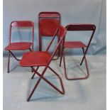 A set of four vintage red metal folding chairs