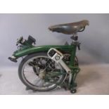 A green Brompton folding bicycle