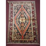 A North-East Persian Turkoman carpet, repeating elephant pad motifs on a rouge field, complimented