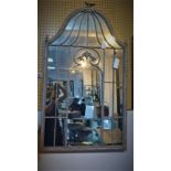 A metal framed arched mirror, with central bird finial, 128 x 71cm