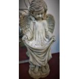 A large cast plaster angel holding her robe at the front to form a bird feeder, H.93cm