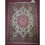 A small Persian Isfahan rug, central floral medallion with stylised floral motifs on a pink and