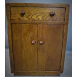 A 1940's oak bedside cabinet, with single drawer above two cupboard doors, H.64 W.46 D.40cm