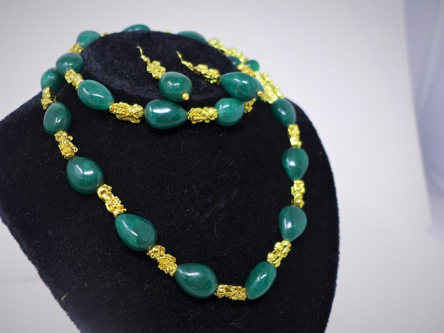An emerald necklace with gilt metal dogs of Fo, together with matching earrings