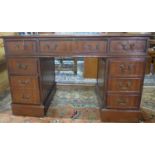 A 20th century mahogany pedestal desk with green leather skiver, having one long and two short