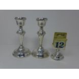 A pair of filled silver candlesticks, by W.I. Broadway & Co., Birmingham 1960, on circular bases,