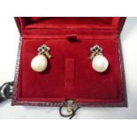 A pair of large white pearl drop earrings with diamond bow tops, boxed