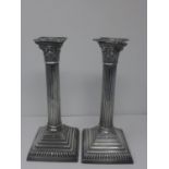 A pair of Mappin & Webb Prince's plate Corinthian column candlesticks, raised on stepped square