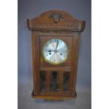 A 20th century oak wall clock, with silvered Arabic dial, having glazed door, H.53 W.28cm