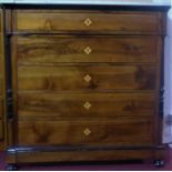 A mahogany and ebonised chest of five drawers with marble top, having ebonised and turned pillars