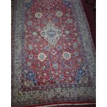 An American Sarouk rug, central floral medallion and floral motifs on a rouge field, within floral