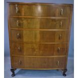 An Art Deco walnut bow fronted chest of five drawers, with Bakelite mounted handles, raised on