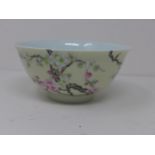 A Chinese famille rose bowl, decorated with blossoming branches, having Chinese inscription to