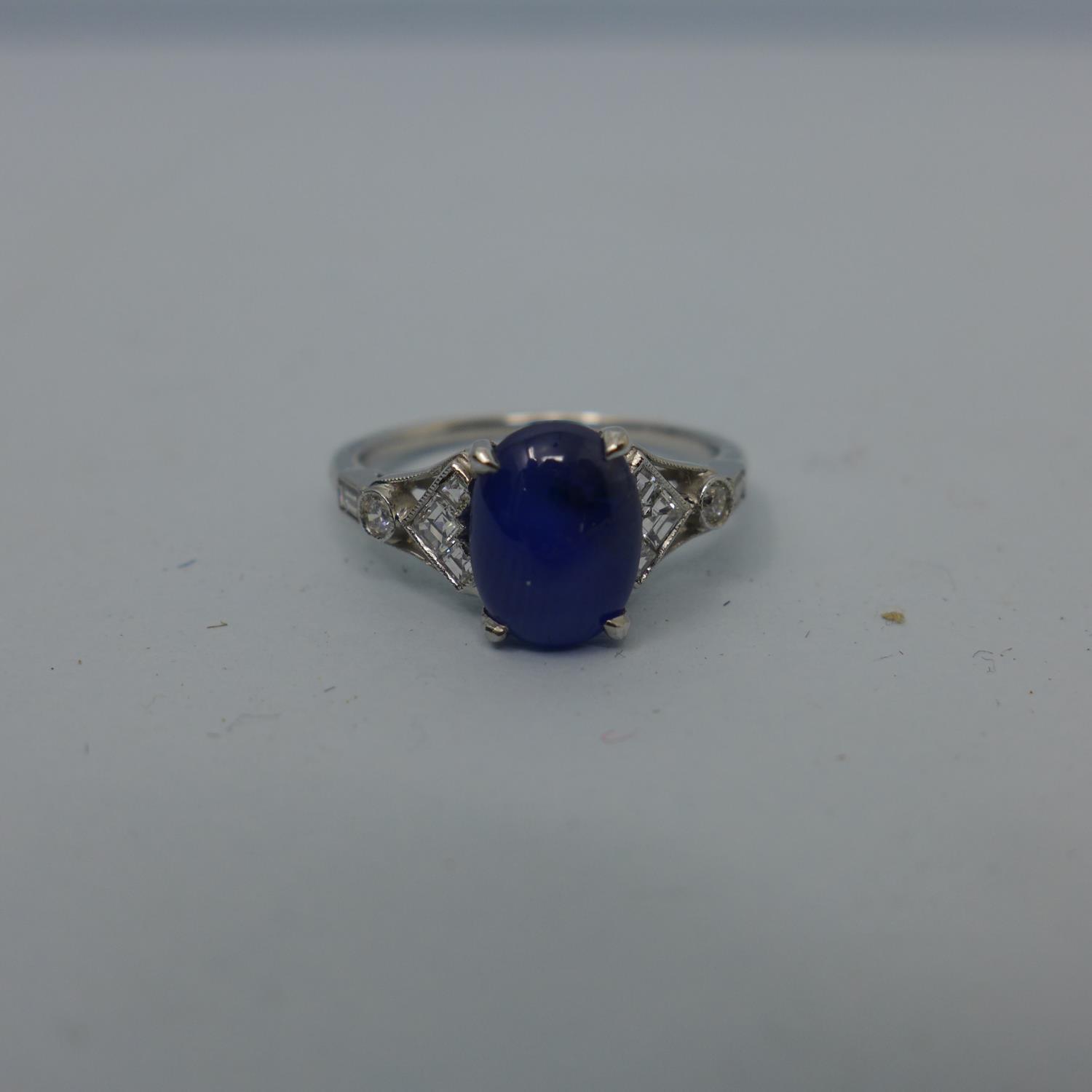 A platinum ring set with translucent blue oval double cabochon sapphire and 10 colourless - Image 2 of 5
