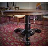 A 19th century mahogany circular dining table, raised on ebonised turned support on tri-form base