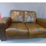 A brown two seater leather sofa, H.80 W.155 D.94cm