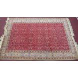 A mid 20th century Persian style Anatolian hand-made rug, all-over floral motifs on a rouge field,