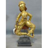 A Southeast Asian gilt painted wooden figure, on stepped square stand, with seal attached to arm,