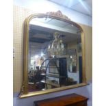 A large 19th century gilt wood over mantle mirror, with scrolling foliage finial,