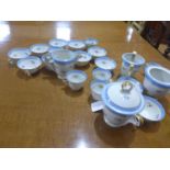 A French porcelain part tea service, decorated with flowers and having blue and gilt rims, to