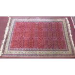 A mid 20th century Persian style Anatolian hand-made rug, all-over petal motifs on a rouge field,