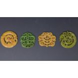 Four Chinese hardstone pendants, carved with dragons and scrolling foliage, W.8cm (largest)