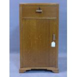 An Art Deco oak pedestal cabinet, with Bakelite handles, with single drawer above cupboard door,