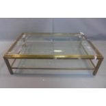 A large French brass and glass two tier coffee table, c.1960, H.39 W.140 D.90cm
