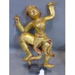 A Southeast Asian gilt painted wooden figure of a dancing man, raised on stepped rectangular