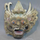 A Southeast Asian polychrome painted carved wooden dragon mask, with lead seal attached, H.23 W.23cm