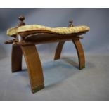 A 20th century camel stool, with wild cat skin and camel hide cushion, on stud bound bowed legs, H.