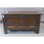 A 19th century oak coffer, with three front panels with carved diamond medallions and carved frieze,