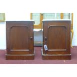 A pair of late 19th / early 20th century mahogany pot stands, with marble tops above cupboard doors,